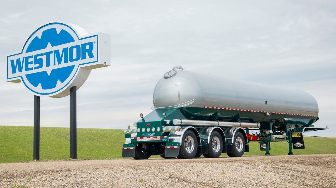 Westmor Proline transport trailer with gray and green tank parked on a gravel lot.
