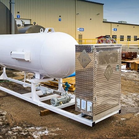 Base cabinet series skid with a horizontal storage tank mounted on a frame and a diamond-plate equipment cabinet at one end.