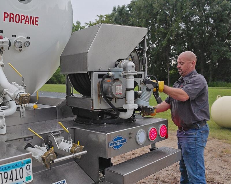 Propane delivery driver operating Westmor’s swiveling hose reel. 