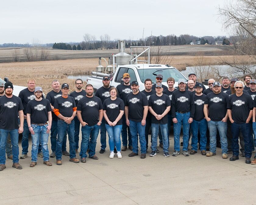 Group photo of Westmor team members standing in front of Westmor service trucks.